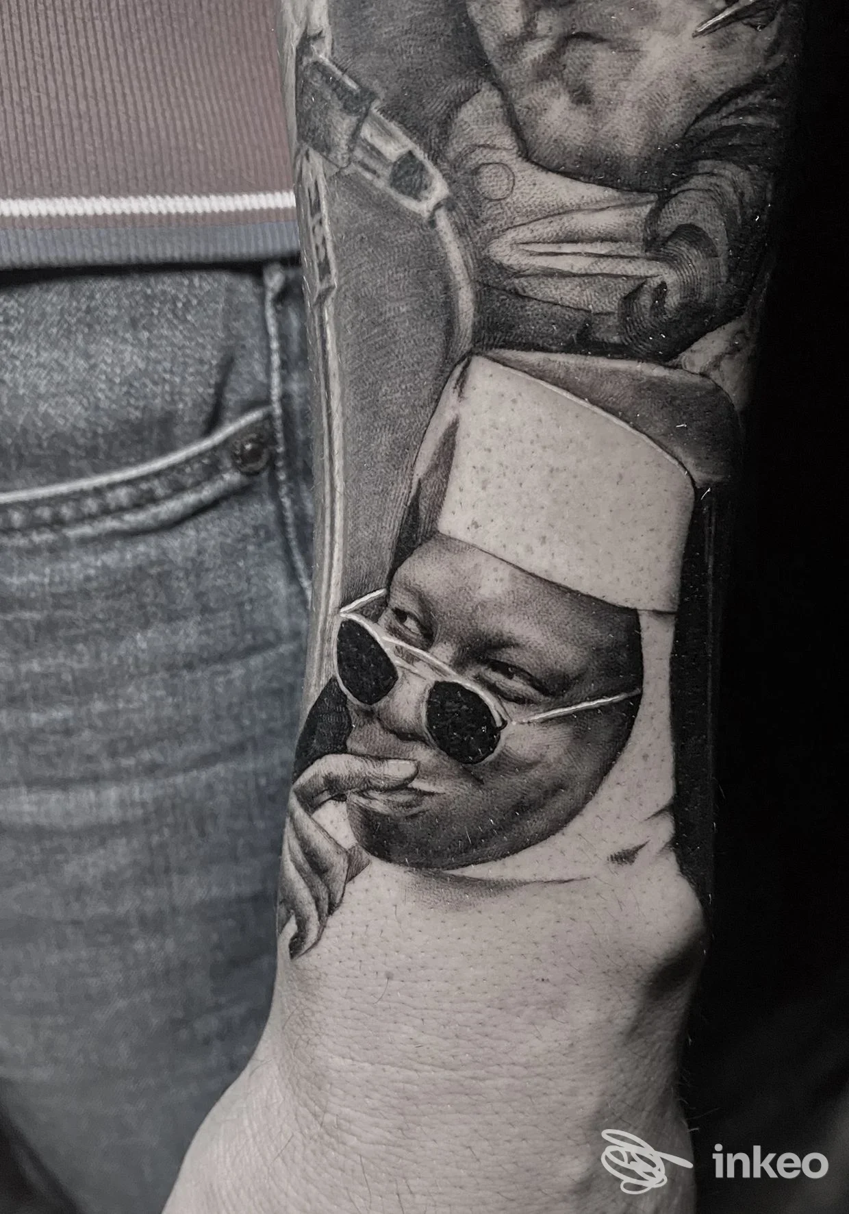 Tatuaggio realistico in bianco e nero su avambraccio: ritratto di suora con occhiali da sole. Will Tattoo 1st, Bari.