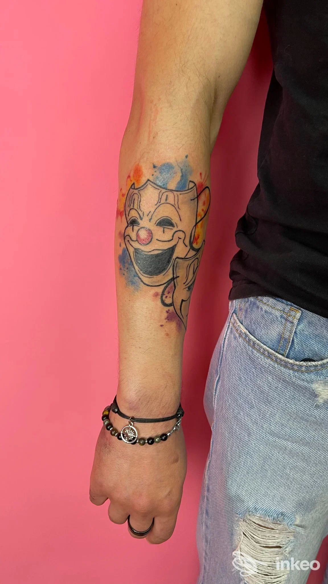 Tatuaggio clown in stile watercolor sull'avambraccio, realizzato da Wonderland Tattoo Studio a Lucera.
