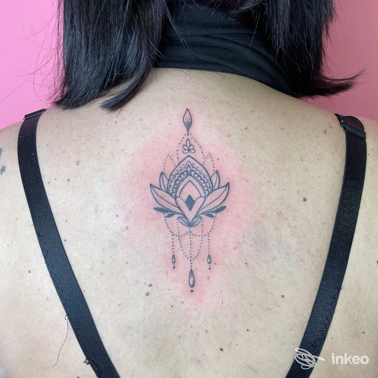 Tatuaggio ornamentale a forma di loto/mandala sulla parte superiore della schiena, lavoro fotografato da vicino, realizzato da Wonderland tattoo studio a Lucera.