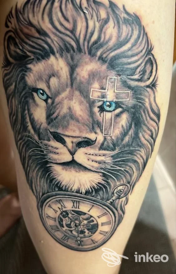 Tatuaggio realistico di un leone con occhi azzurri, croce e orologio da tasca; THE WOLF Tattoo&piercing STUDIO, San Giovanni Rotondo.