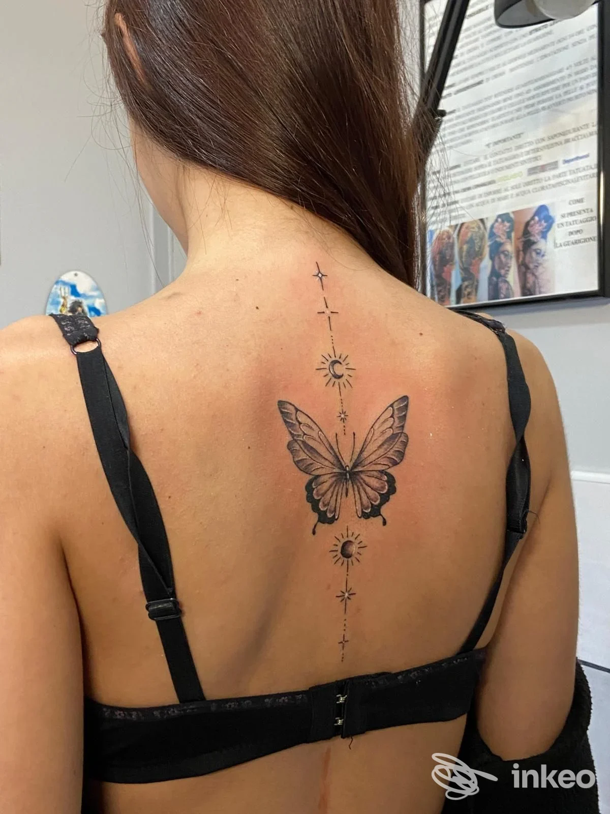 Tatuaggio centrale a farfalla con elementi solari lungo la colonna vertebrale, foto dallo studio THE WOLF Tattoo&piercing, San Giovanni Rotondo.