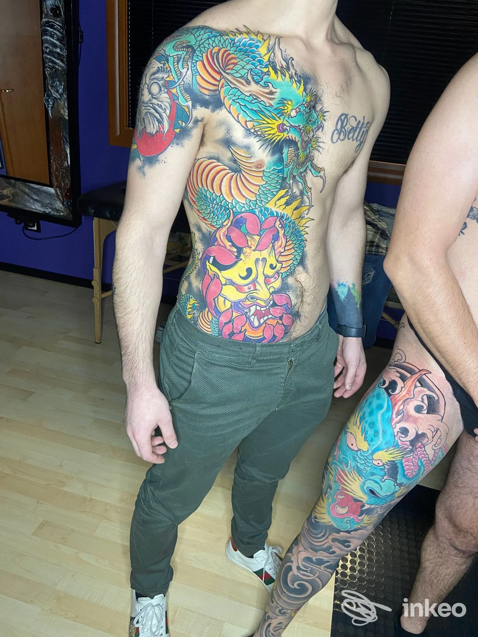 Ampio tatuaggio colorato a fianco e torace con drago e maschera, foto fornita da ANANDA INK Tattoo e Piercing, San Nicandro Garganico.