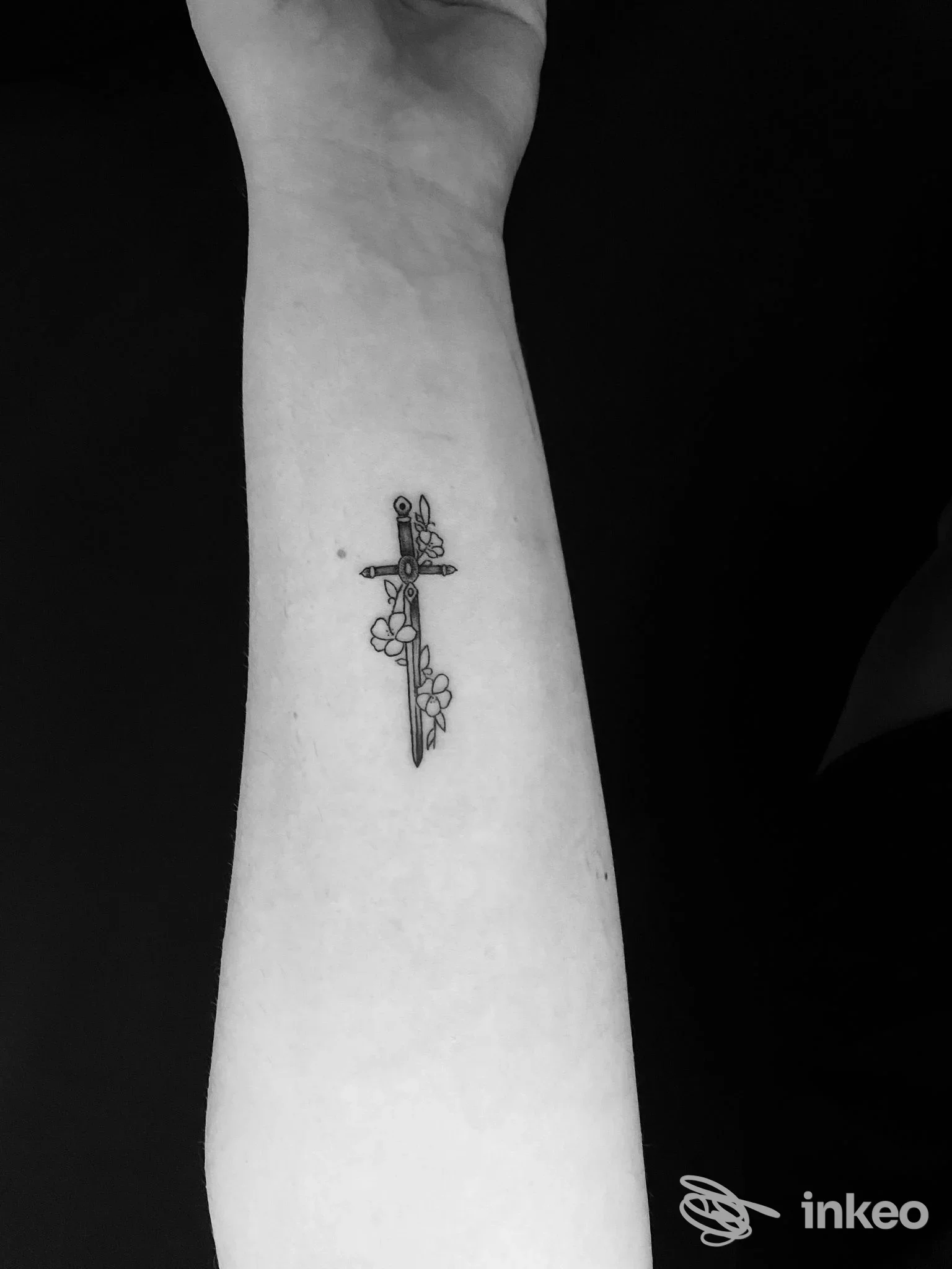 Tatuaggio sottile a pugnale con fiori sull'avambraccio, fotografia presente nell'archivio di Anthony Tattoo Art, Adelfia.