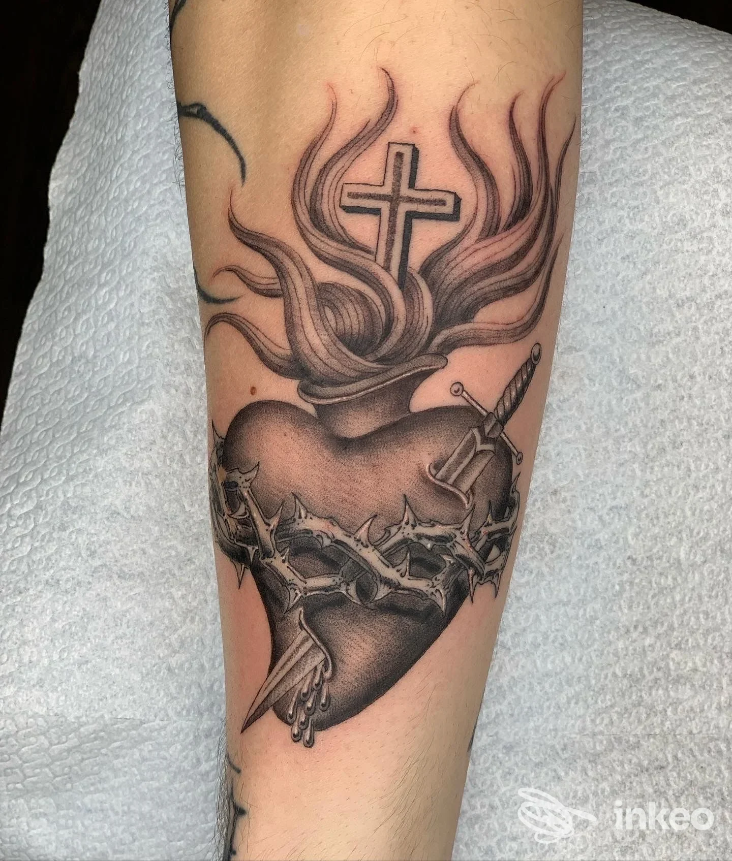 Tatuaggio cuore sacro con corona di spine, croce e pugnale sull'avambraccio. Antipop Tattoo, Foggia.