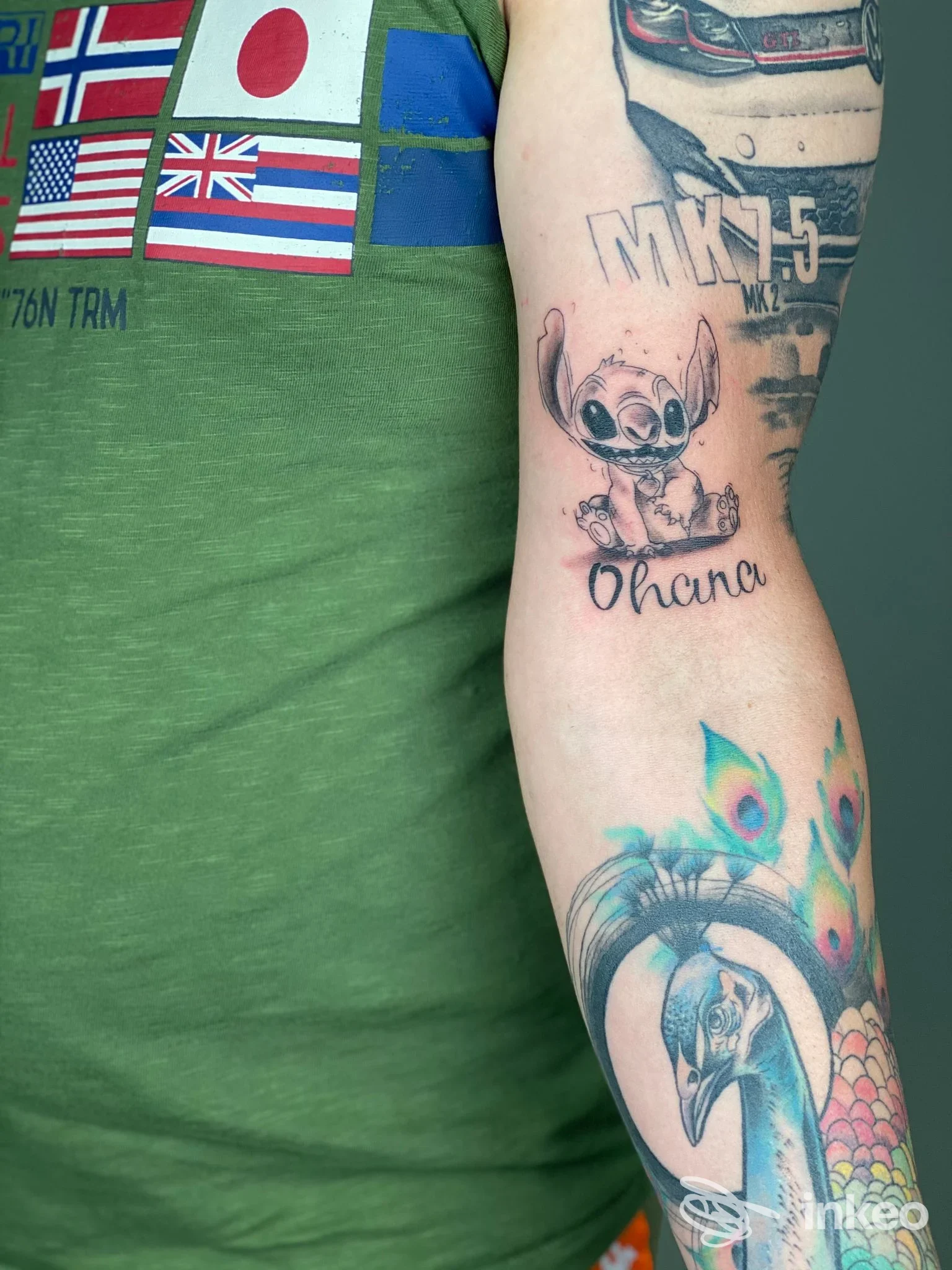Avambraccio tatuato con personaggio “Ohana” e grande pavone, foto per Arosa Tattoo Studio a Tricase.
