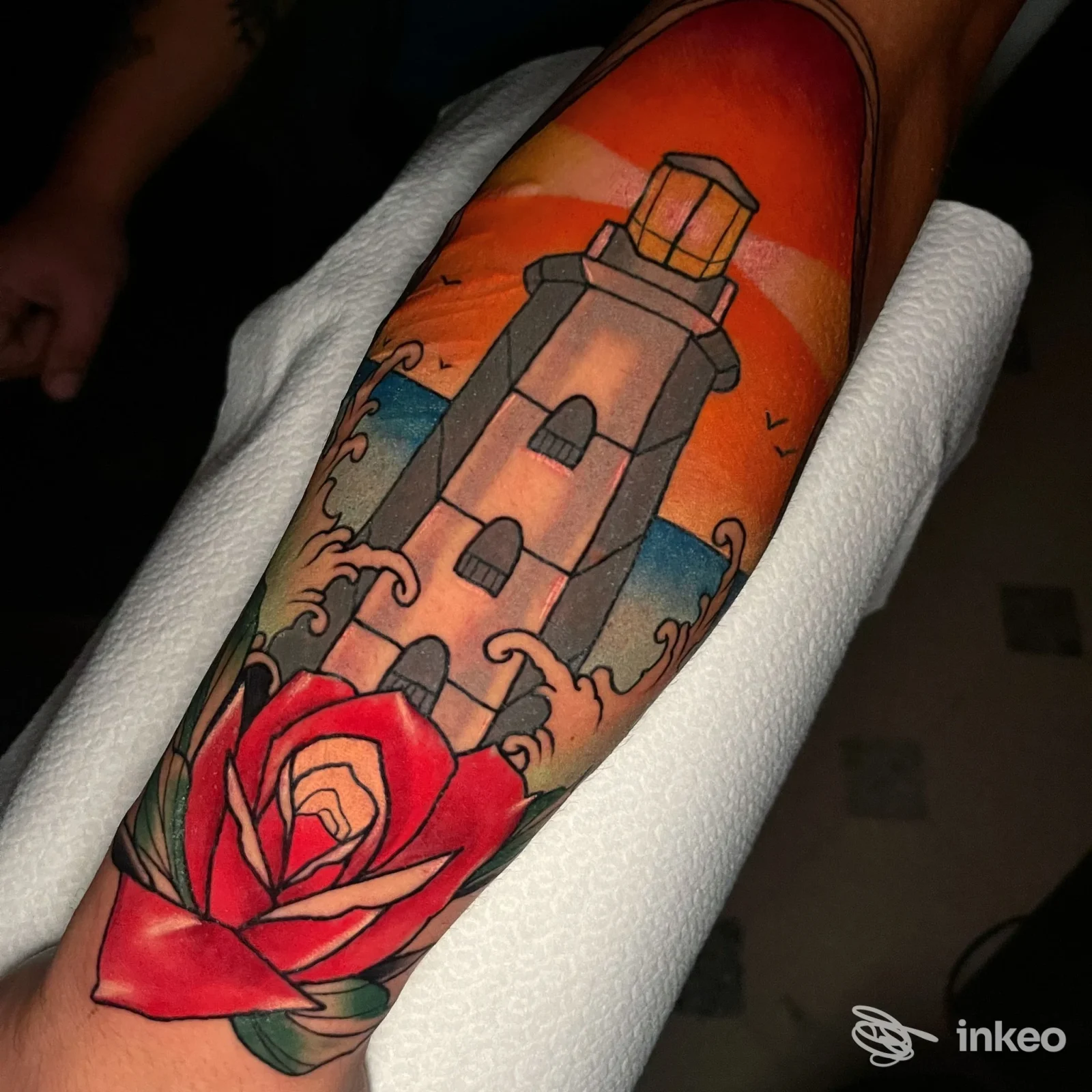 Tatuaggio a colori sull'avambraccio con un faro e una rosa, realizzato da Black Blood Tattoo & Barber a Casarano.