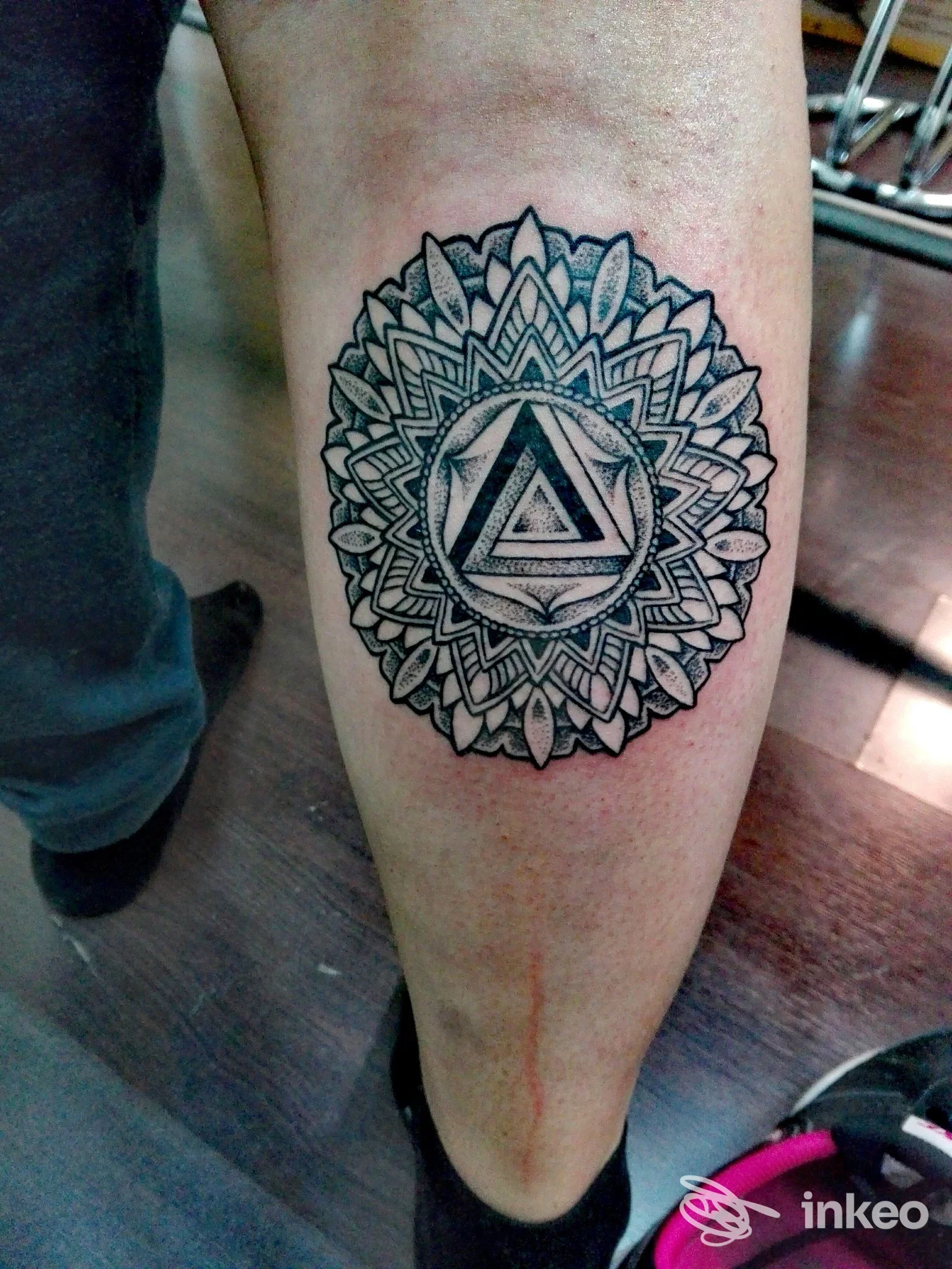 Tatuaggio mandala in bianco e nero sul polpaccio, dettagli puntinati e geometria centrale. Foto fornita da AtipikoTattoo, Bari.