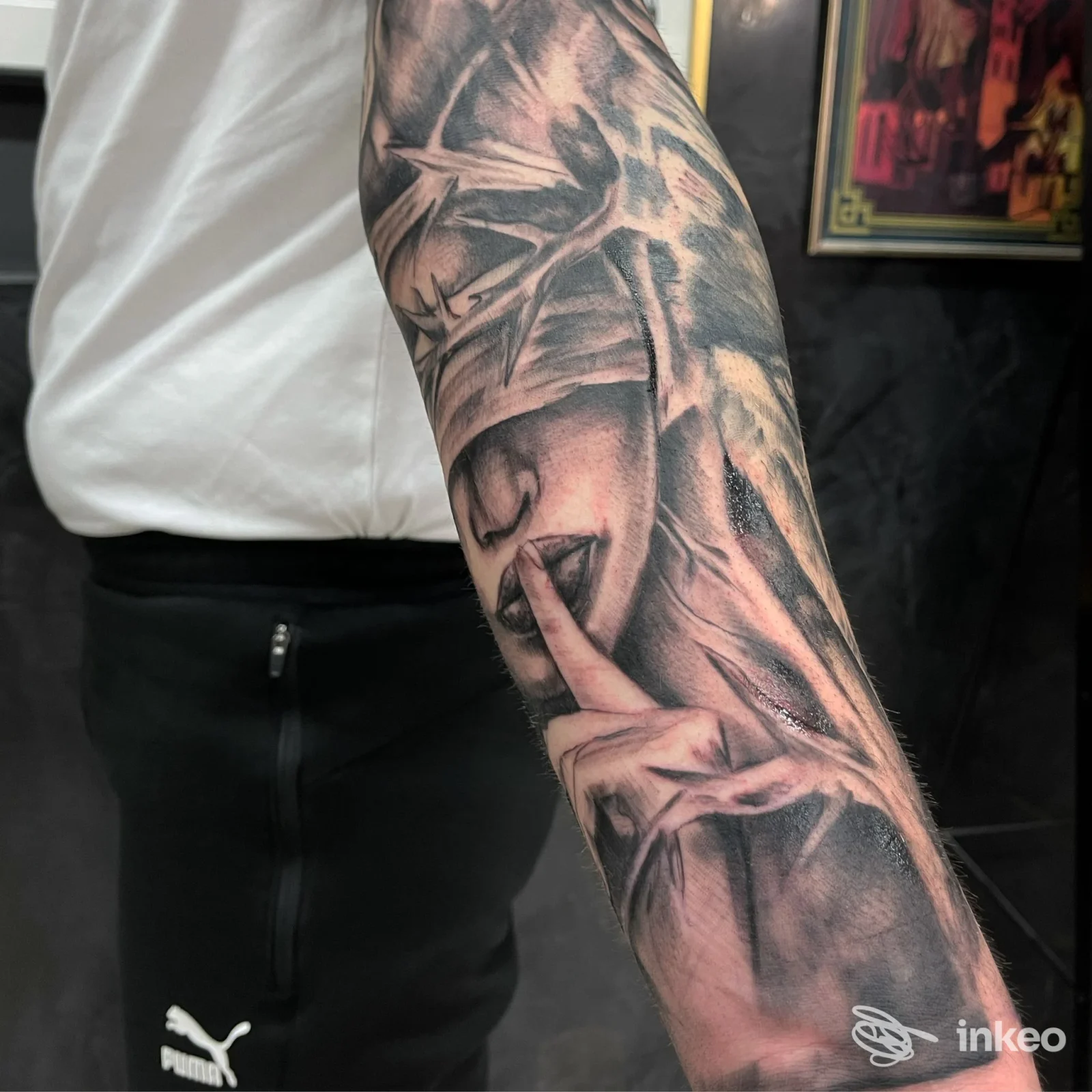 Avambraccio con tatuaggio realistico di volto e mano, scatto singolo al Black Mirror Tattoo ad Andria.