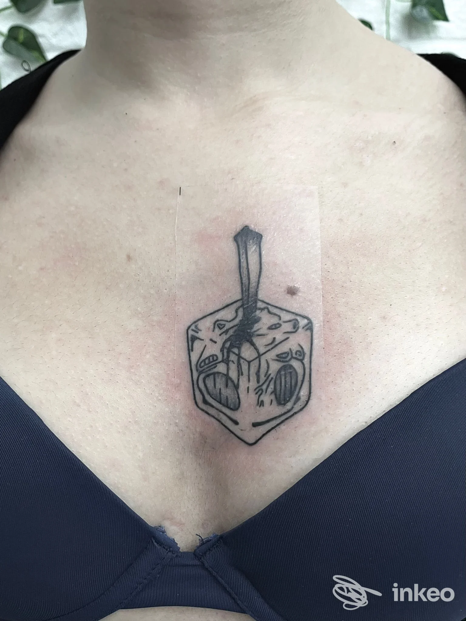 Tatuaggio blackwork a forma di dreidel sul petto, realizzato da Black Rose Tattoo a Galatina.