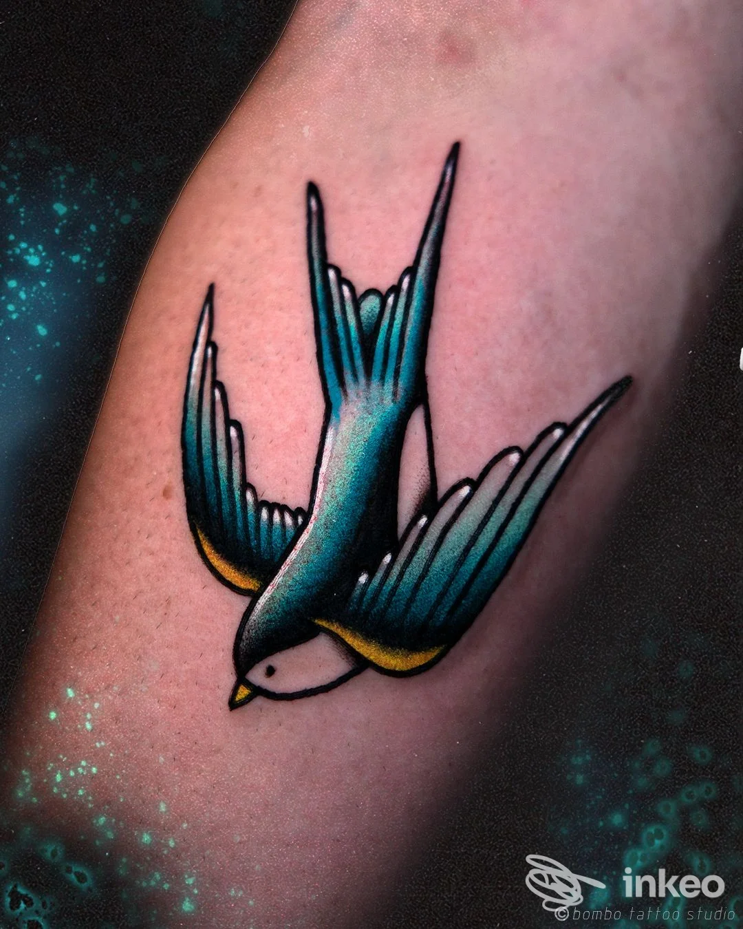 Tatuaggio tradizionale di una rondine colorata su avambraccio, fotografato per Bombo Tattoo Studio a Foggia.