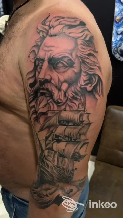 Tatuaggio realistico su braccio superiore: volto barbuto e grande veliero, Broken Art tattoo studio, Bari.