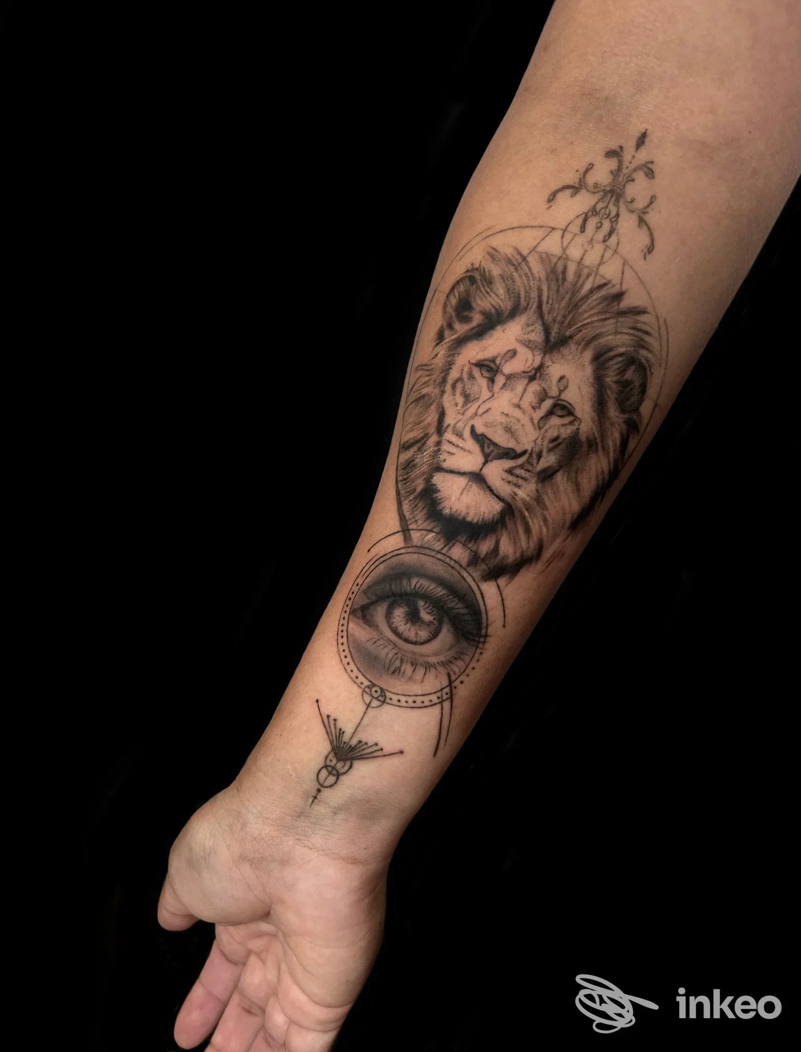 Tatuaggio su avambraccio con ritratto di leone e occhio in bianco e nero, immagine fornita da Celeste Schifano Tattoo Studio, Maglie.