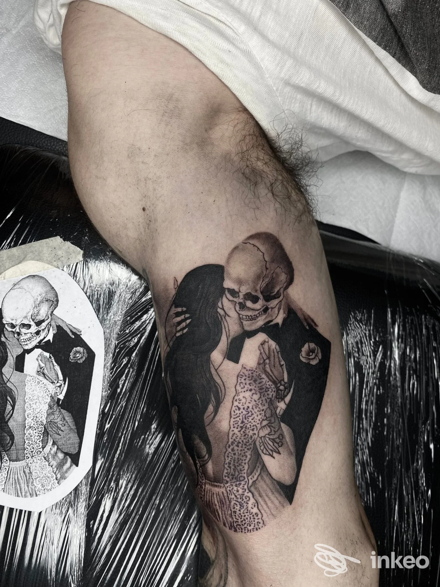 Tatuaggio black & grey su braccio: figura scheletrica che bacia una donna, Bunker - Tattoo Studio, Monopoli.