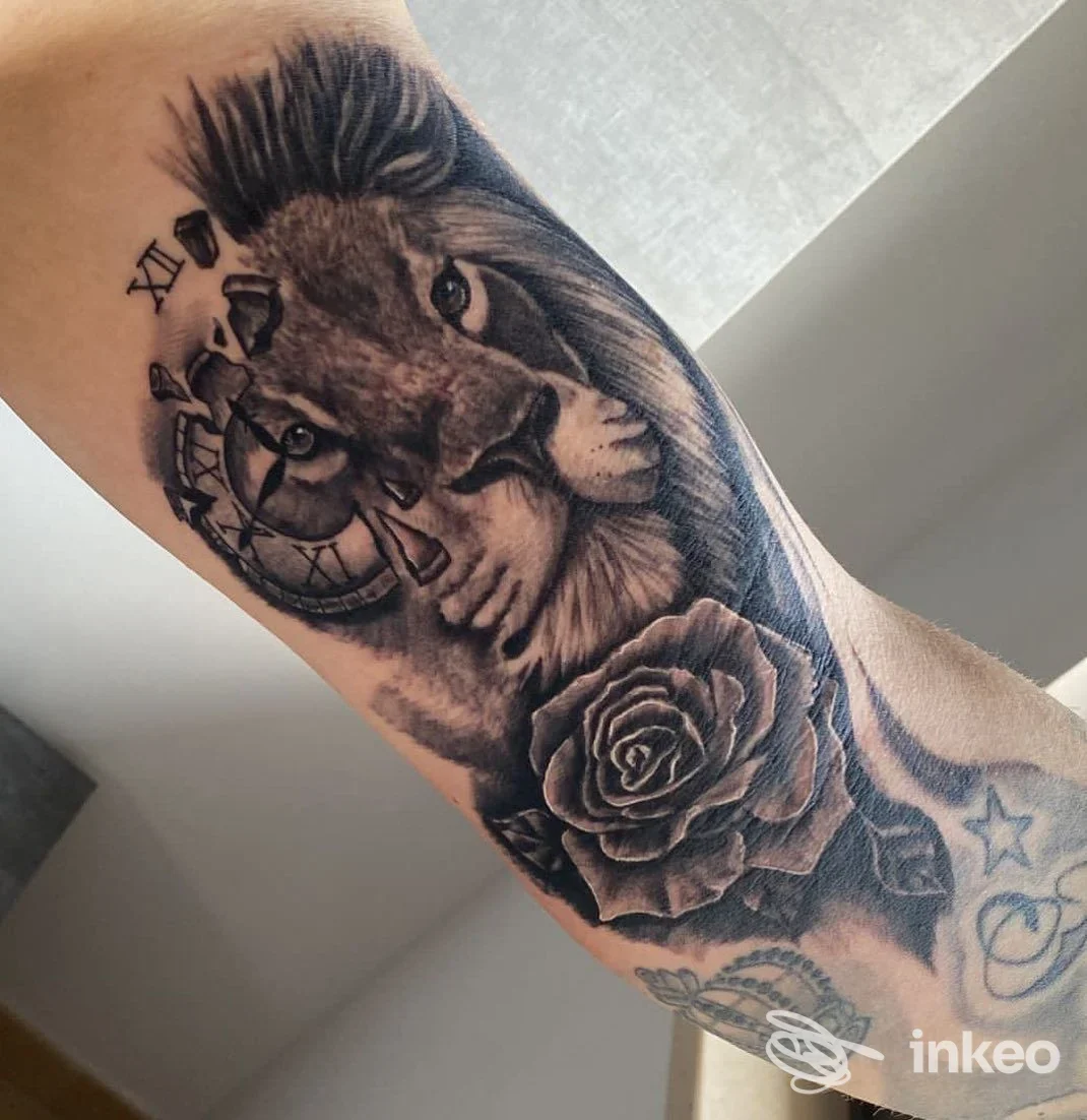 Tatuaggio in bianco e nero con leone, orologio rotto e rosa su avambraccio, Gerardo Marchionna Tattoo e Piercing, Cellamare.