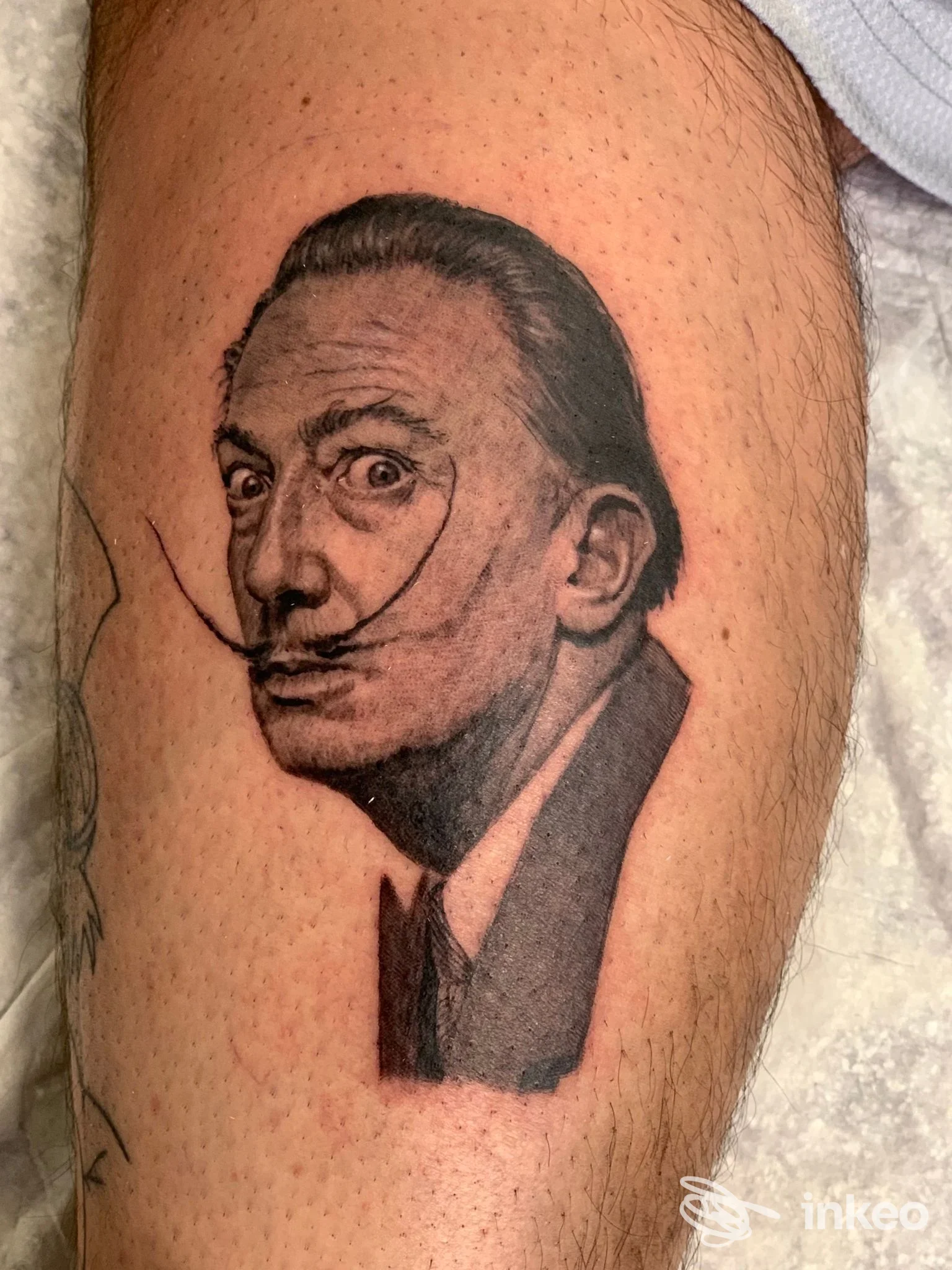 Ritratto tatuato in bianco e nero sul polpaccio, opera condivisa da Giuseppe Buzzerio Tattoo a Cassano delle Murge.