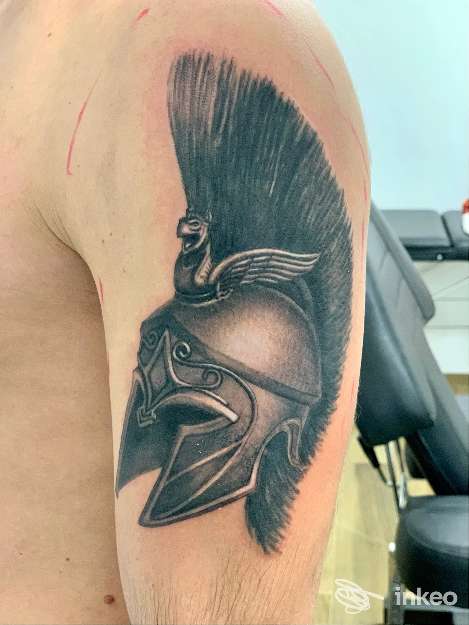 Tatuaggio realistico in bianco e nero di un elmo corinzio sul deltoide, foto inviata dallo studio Giuseppe Buzzerio Tattoo a Cassano delle Murge.