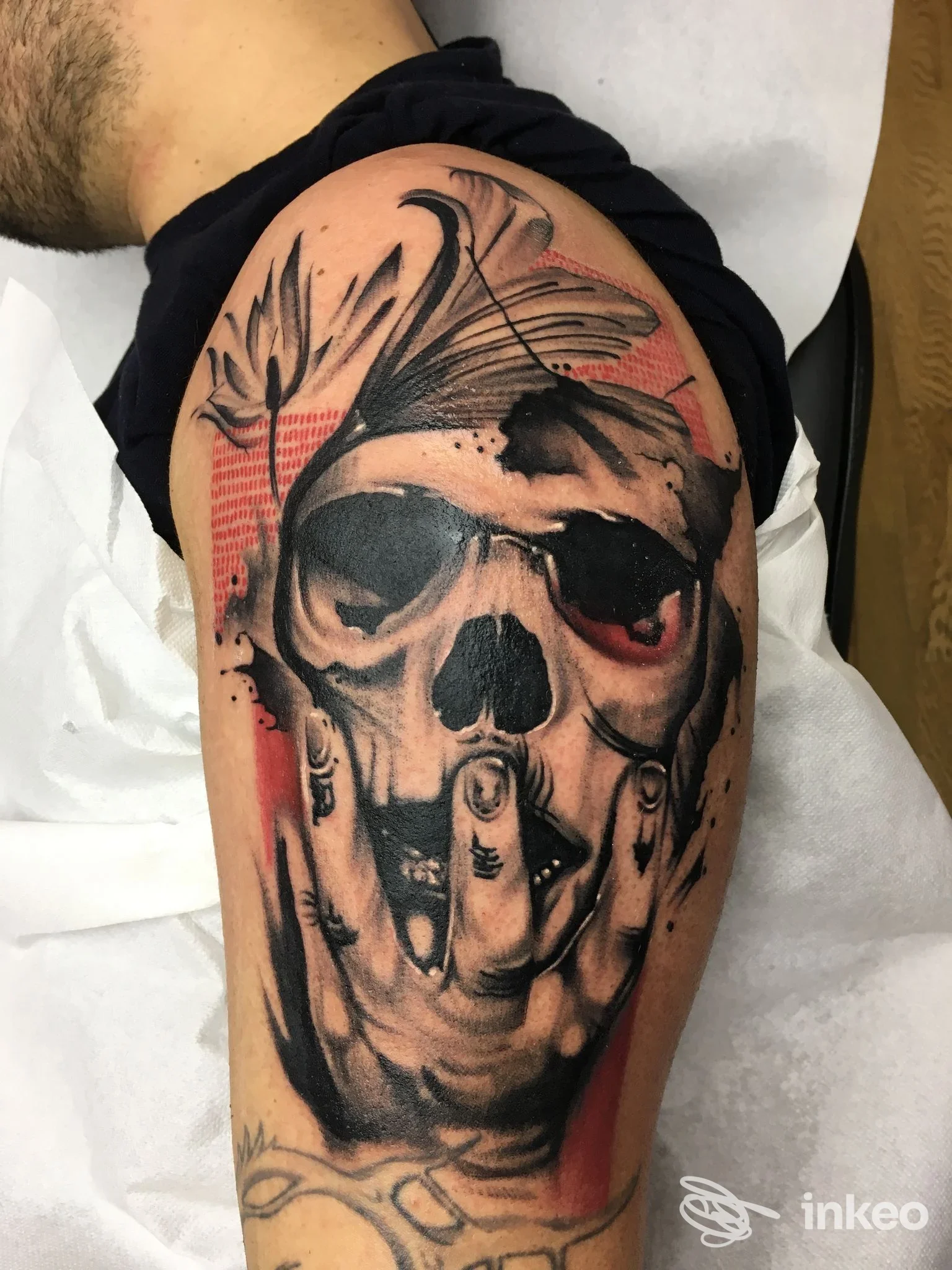 Tatuaggio su spalla e parte superiore del braccio: teschio stilizzato con dettagli neri e rossi, Glam Tattoo di Enea Polimeno, Melpignano.