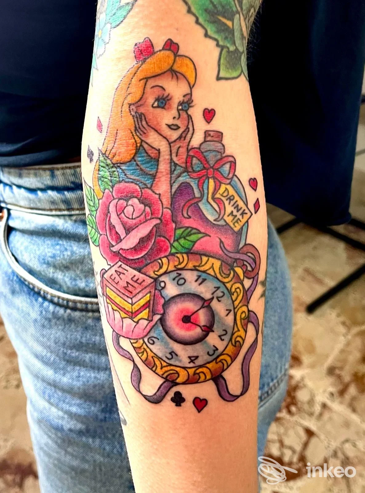 Tatuaggio su avambraccio raffigurante una Alice stilizzata con rosa e orologio, scatto realizzato per Hell Diver Tattoo Studio, Lecce.