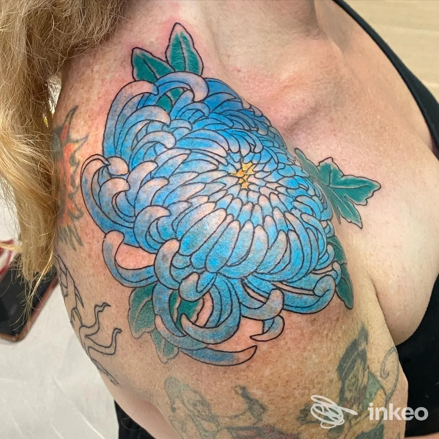 Grande tatuaggio floreale blu sulla spalla e alto braccio, foto fornita da Hell Diver Tattoo Studio, Lecce.