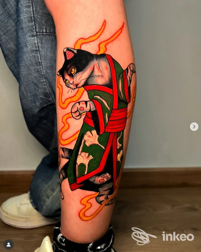 Tatuaggio su polpaccio con gatto in kimono e fiamme, immagine di Holy Flames Tattoo a Trepuzzi.