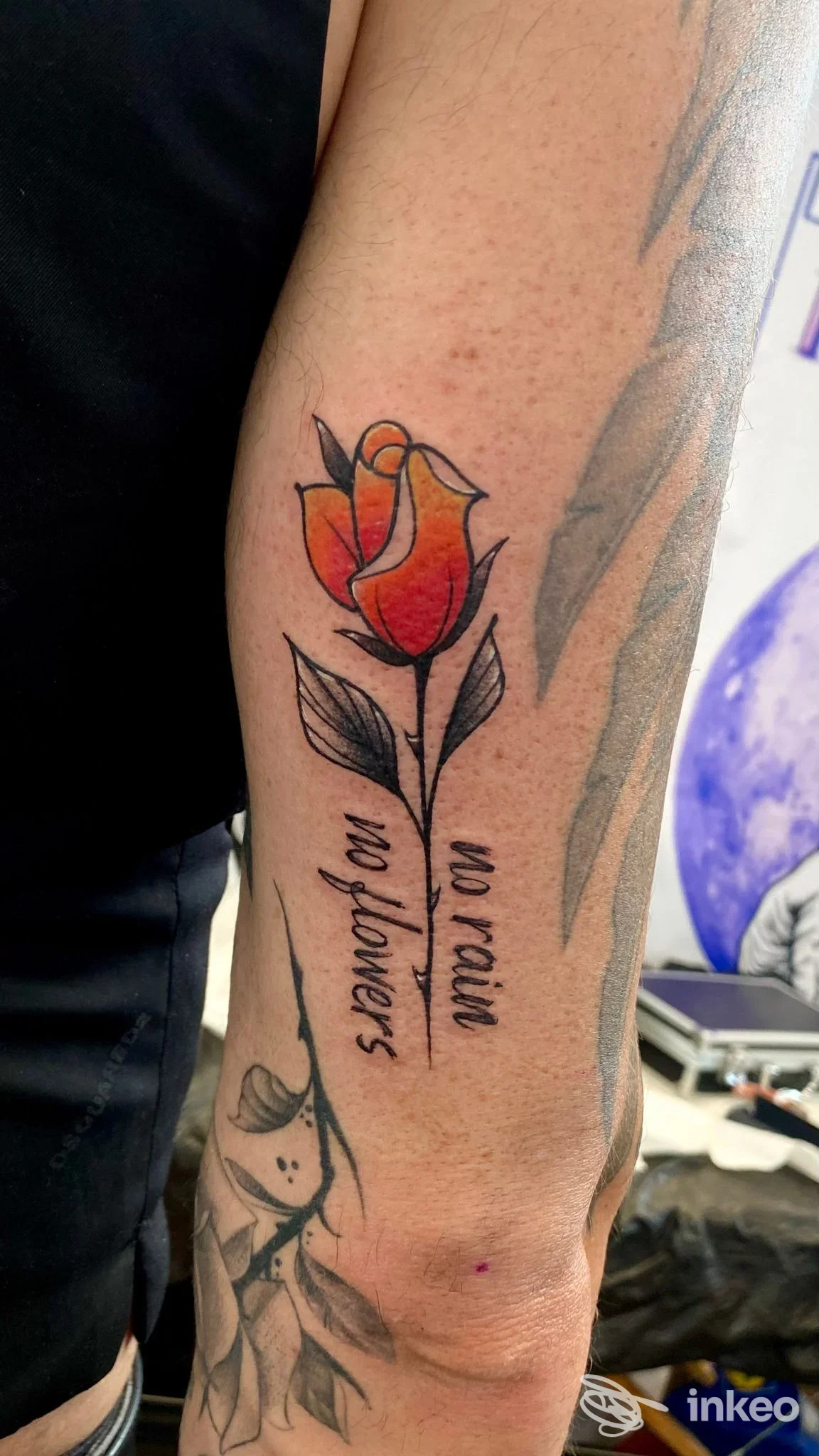 Tatuaggio a forma di rosa colorata con testo verticale sull'avambraccio, foto proveniente da Ink Master Tattoo & Piercing a Giovinazzo.