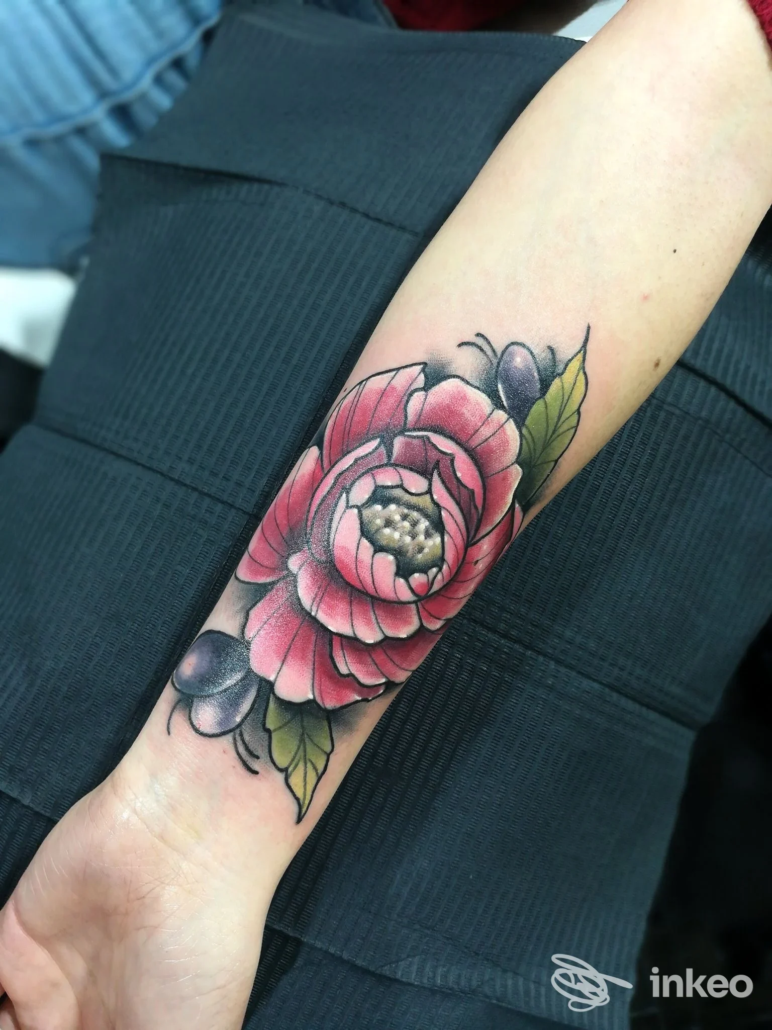 Tatuaggio a colori di un grande fiore rosa sull'avambraccio, realizzato da Jaodaber Tattoo Studio a Carovigno.