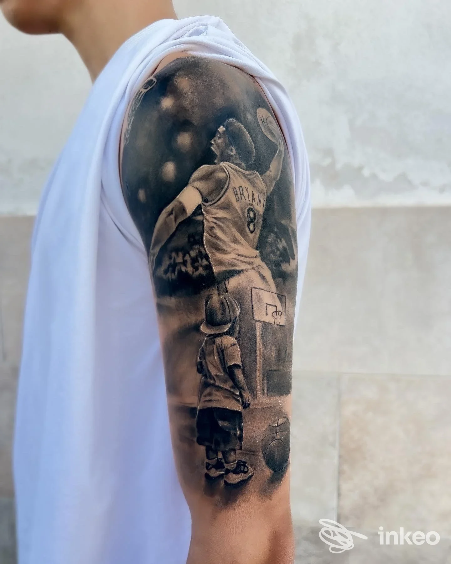 Tatuaggio a tema basket sul braccio con figura di Bryant e scena di un bambino; Jaodaber Tattoo Studio, Carovigno.