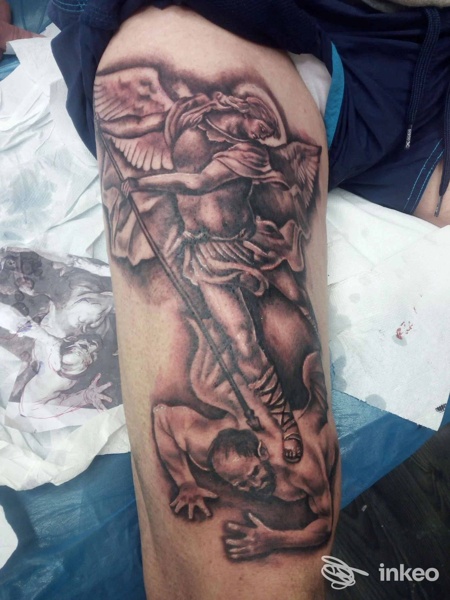 Tatuaggio realistico su coscia eseguito da Jack Tattoo Capurso, Capurso, raffigurante un angelo sopra una figura umana.