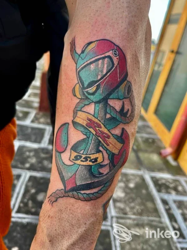 Tatuaggio colorato su avambraccio raffigurante un casco da corsa integrato in un'ancora, Karma Tattoo Studio, Surbo.
