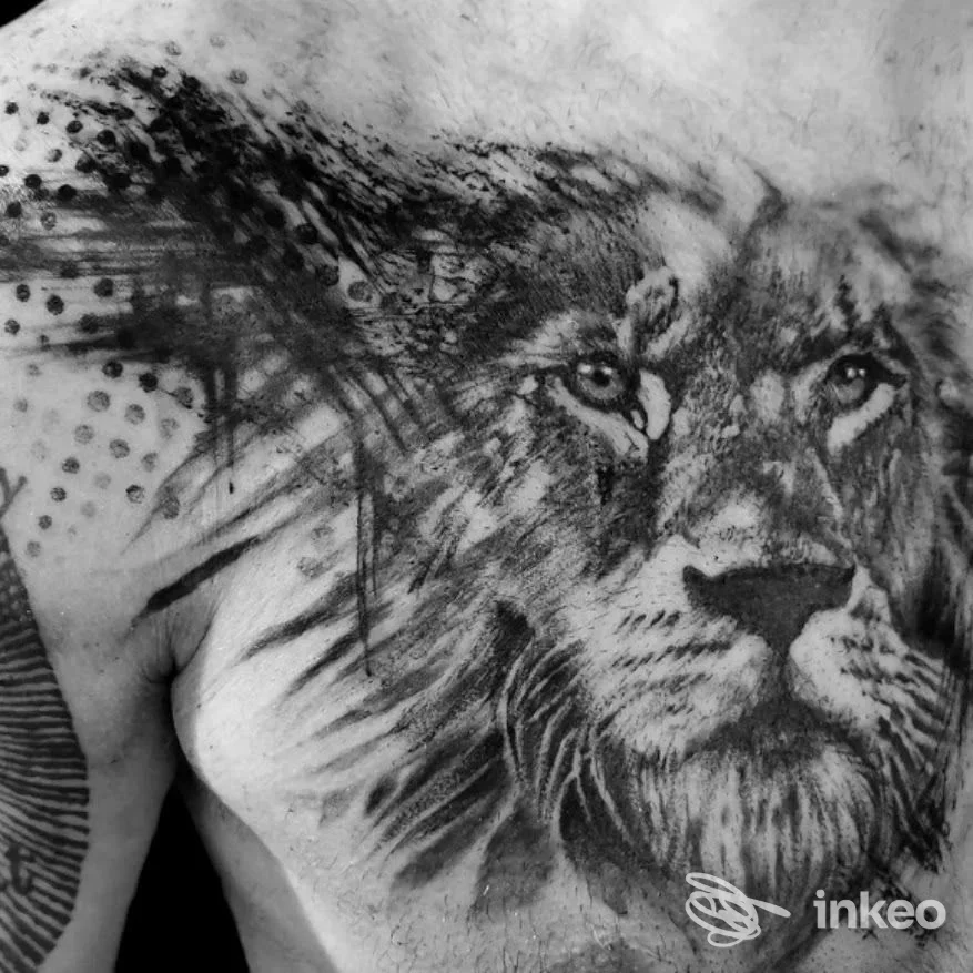 Tatuaggio realistico di leone sul torace e spalla, fotografato su pelle reale. Kefi Tattoo, San Marzano di San Giuseppe.