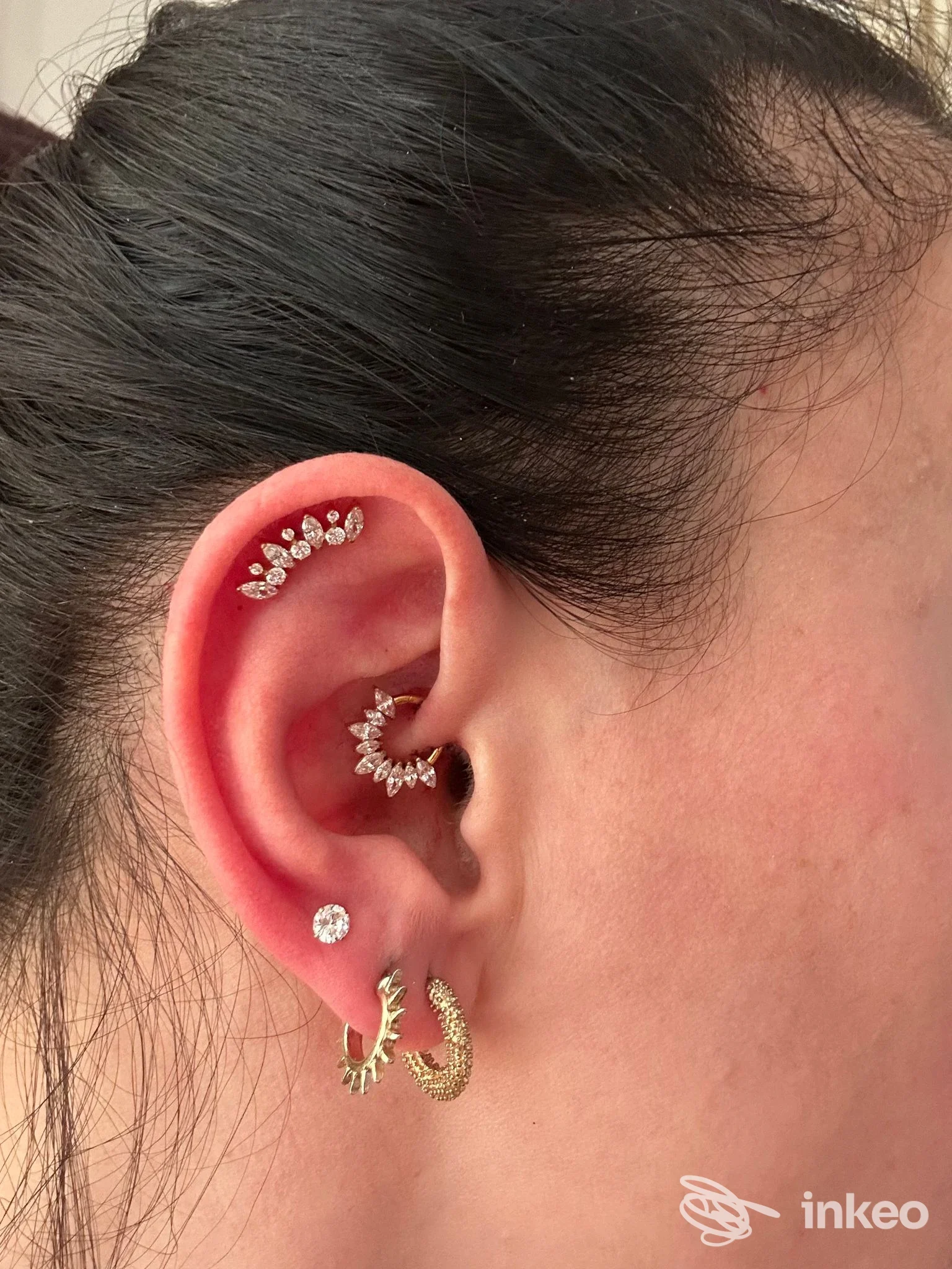 Primo piano di un orecchio con più piercing gioiello; foto fornita da LA LORE PIERCING, Bari.