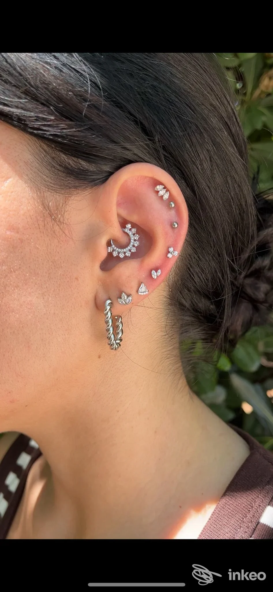 Orecchio in primo piano con diversi piercing eseguiti da LA LORE PIERCING a Bari, dettagli dei gioielli e della conca auricolare.