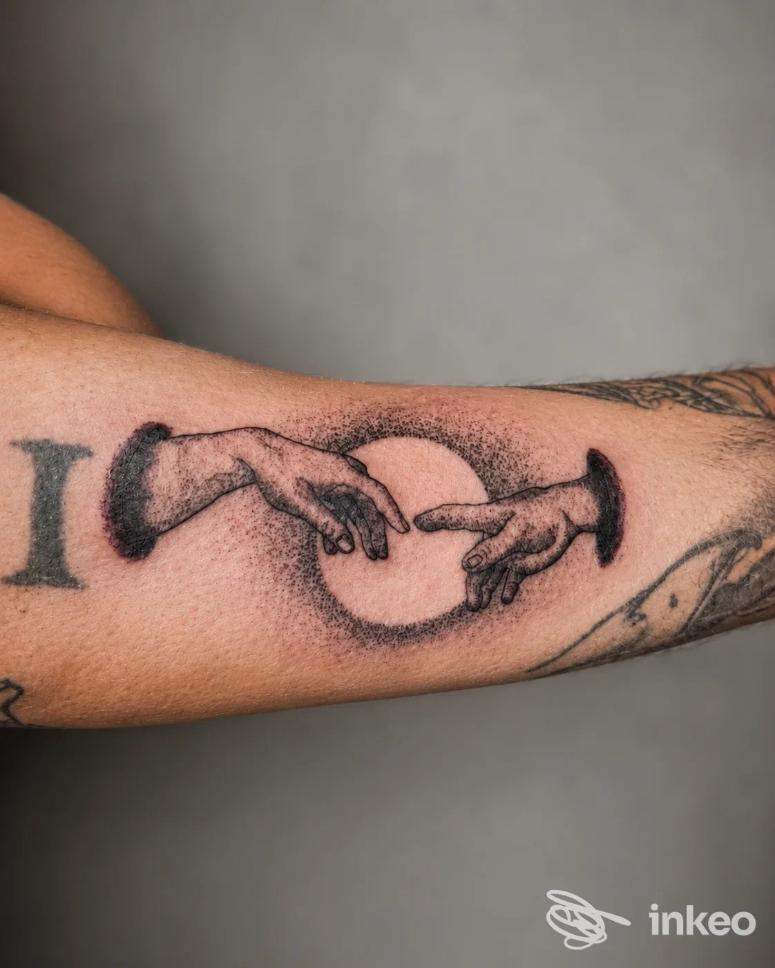 Tatuaggio a puntinismo sull'avambraccio con due mani che si avvicinano e un cerchio centrale, foto per Lady.D ink tattoo e piercing, Castellaneta.