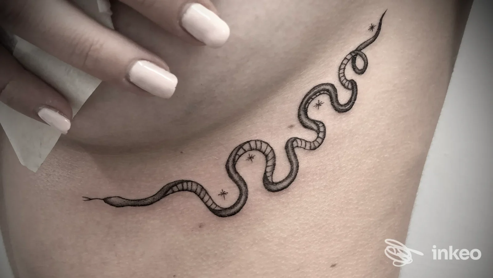 Tatuaggio di serpente minimalista sul fianco, foto inviata da MANA TATTOO •art studio•, Torremaggiore.