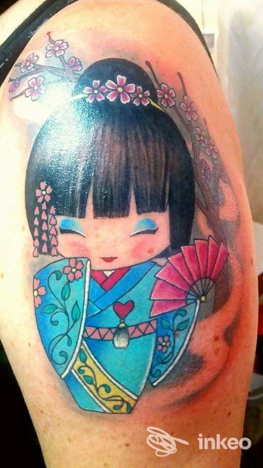 Tatuaggio colorato di una bambola kokeshi con ventaglio e fiori sul braccio, Magic Tattoo di Giorgio Guido, Mesagne.