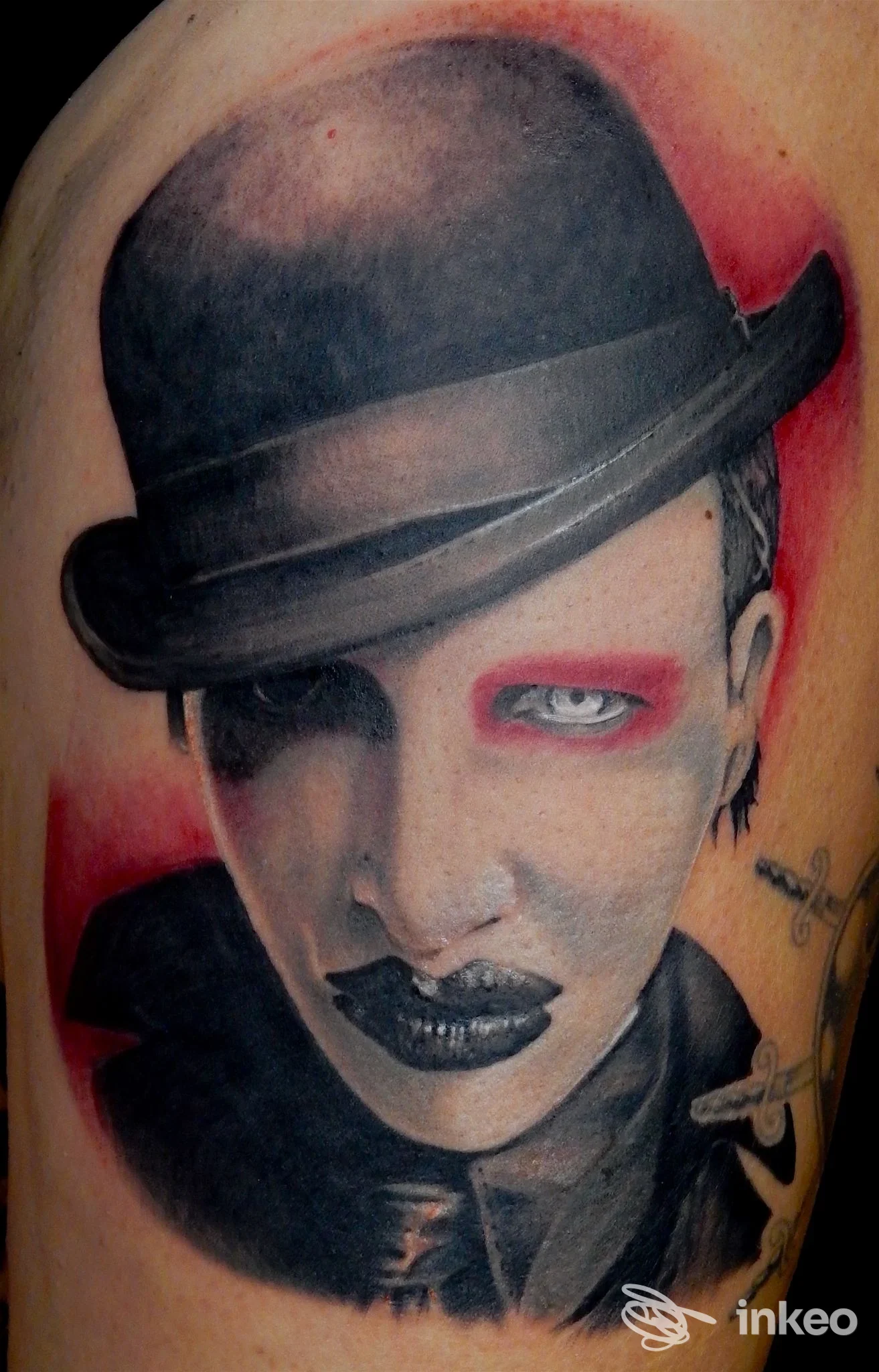 Tatuaggio realistico di un volto con cappello su braccio, Magic Tattoo di Giorgio Guido a Mesagne.