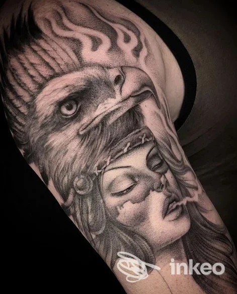 Tatuaggio realistico in bianco e nero sul bicipite con aquila e volto femminile, foto di Más Profundo Tattoo Shop a Taranto.