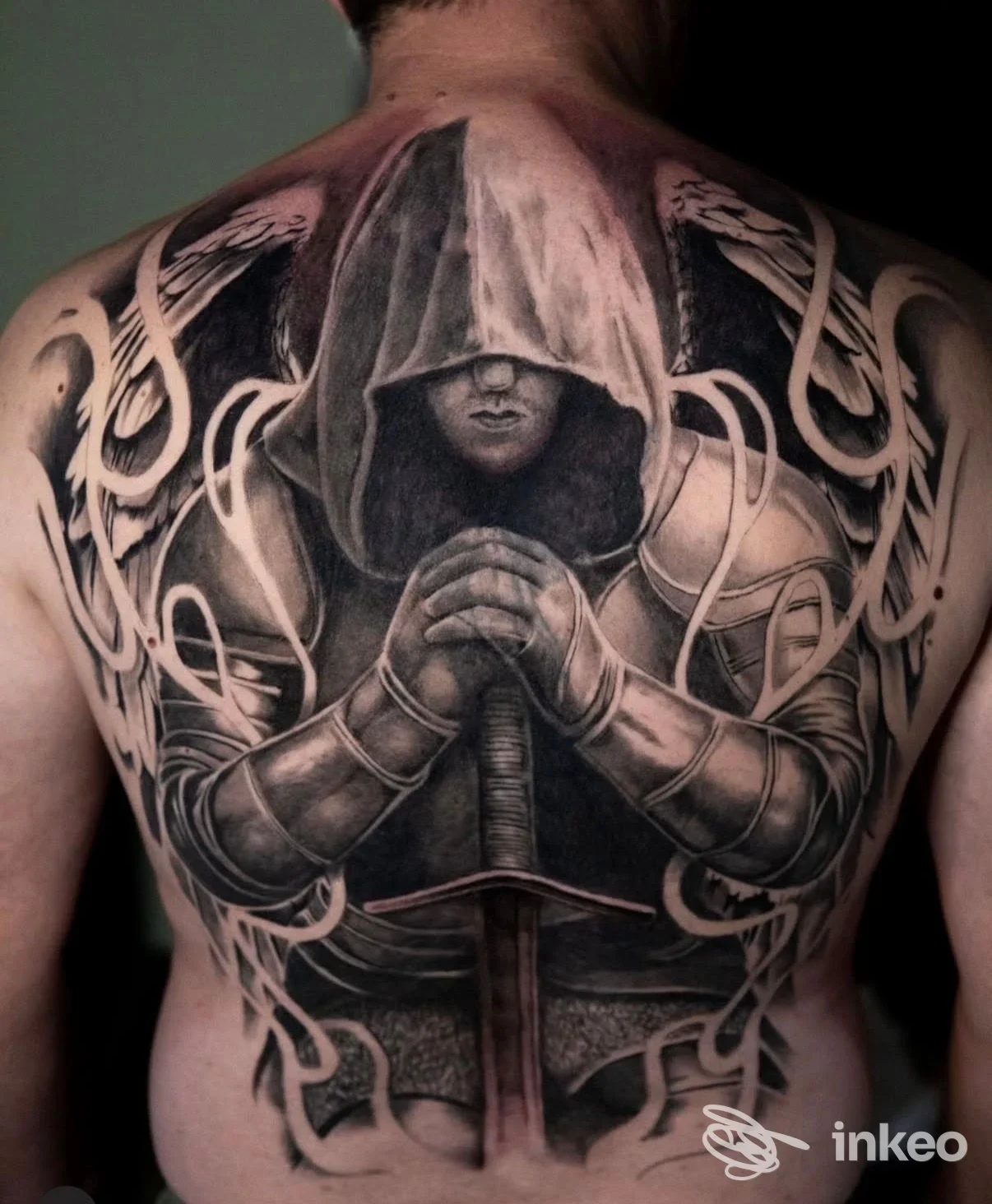 Grande tatuaggio realistico in nero e grigio su tutta la schiena raffigurante un guerriero incappucciato con spada, MANCHADEARTE TATTOO STUDIO, Muro Leccese.