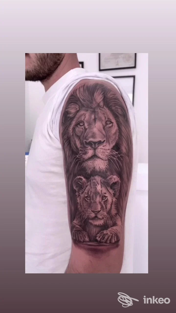 Tatuaggio realistico in bianco e nero con leone e cucciolo sul braccio di un cliente — MC Tattoo Studio, Ugento.