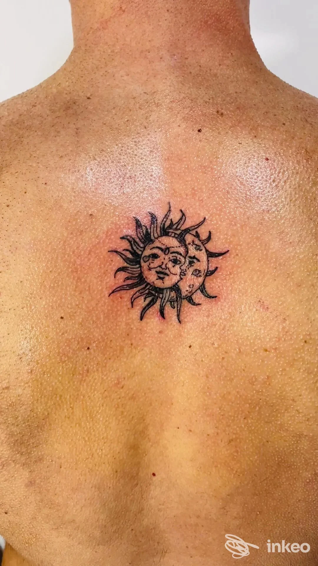 Tatuaggio nero a forma di sole con volto al centro della parte superiore della schiena, fotografato per Macedone Shop Tattoo & Piercing a Bari.