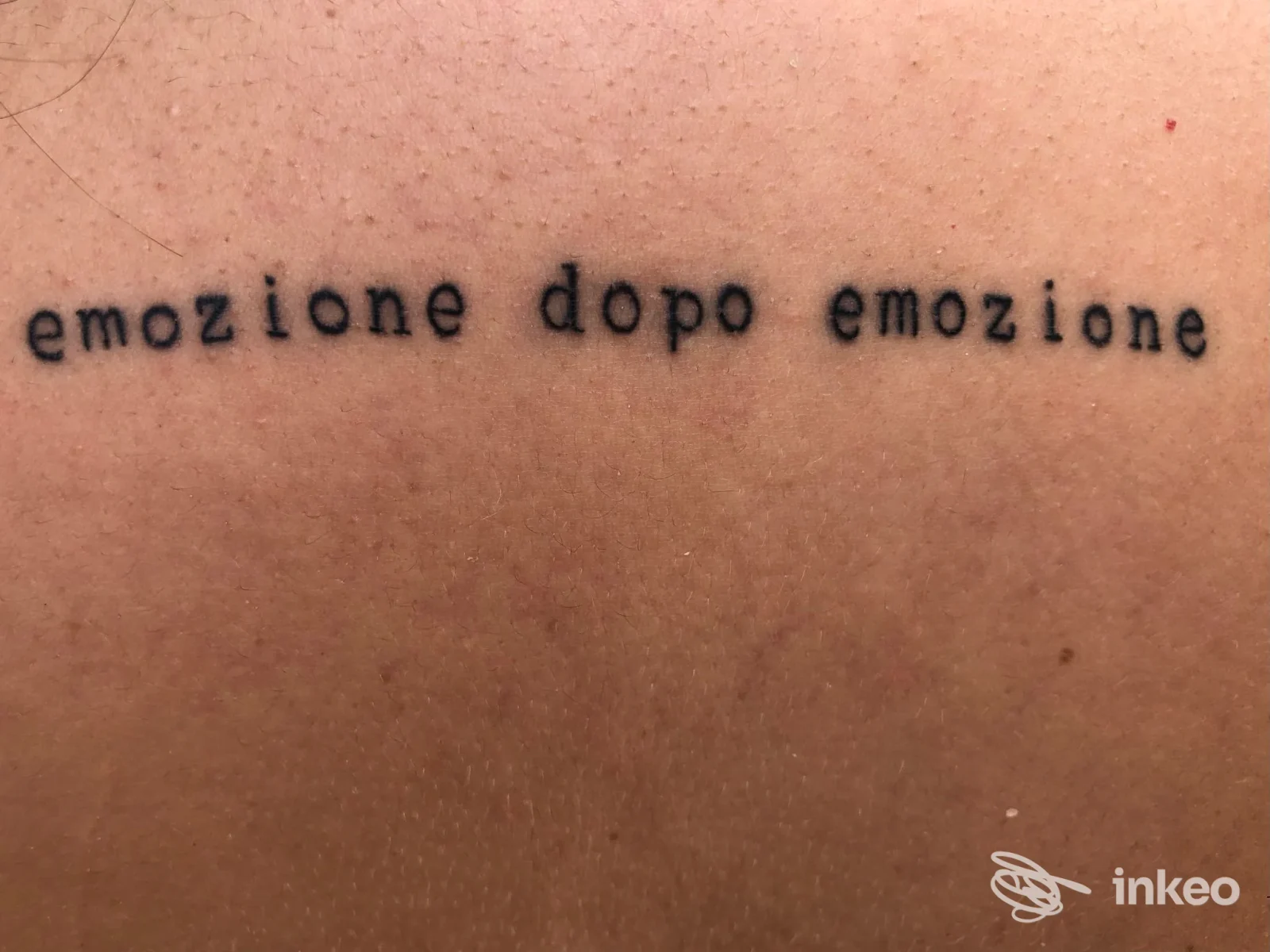 Dettaglio su pelle con tatuaggio testuale "emozione dopo emozione", foto di Marilú tattoo ad Acquaviva delle Fonti.