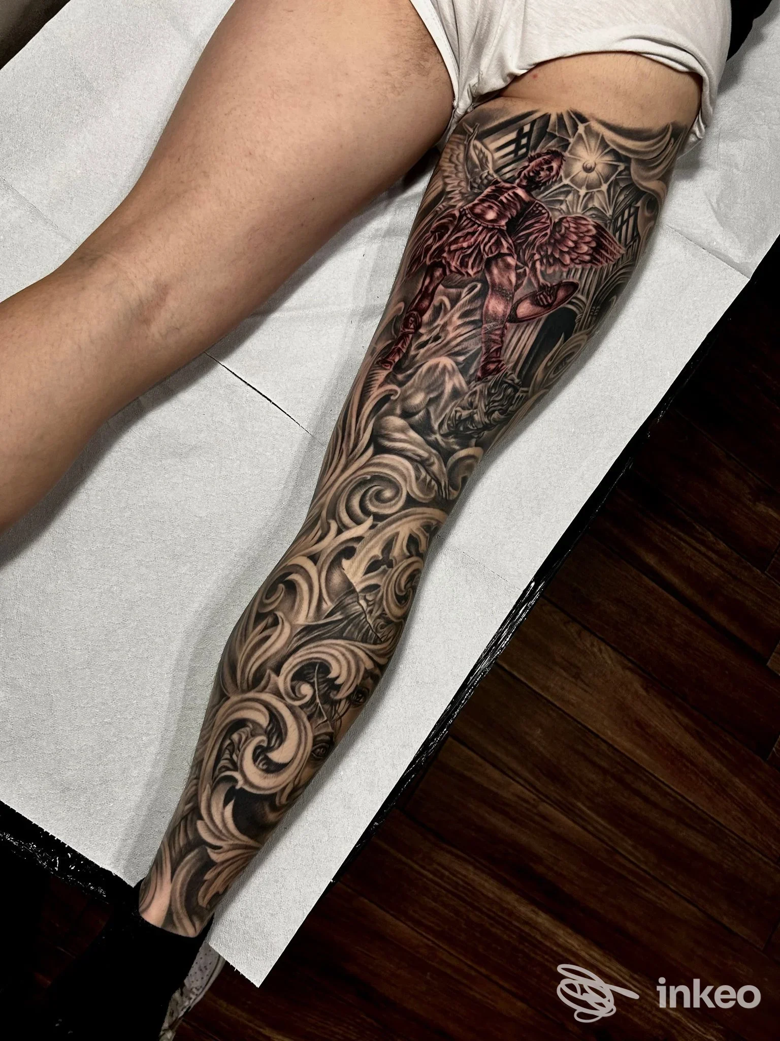 Gamba tatuata dal polpaccio alla coscia con motivi ornamentali neri e una figura rossa, Morello Tattoo, Lecce.