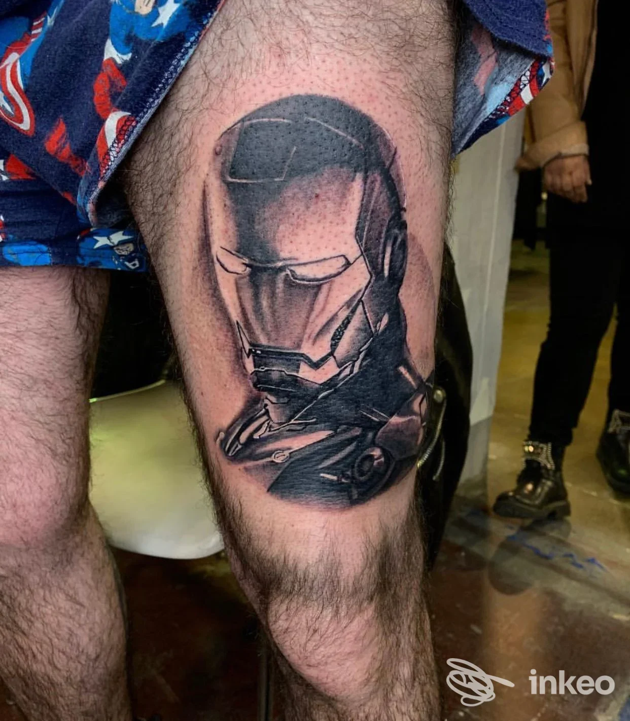 Tattoo realistico su polpaccio raffigurante un casco high-tech, realizzato direttamente sulla pelle di una persona, senza avatar o elementi digitali.