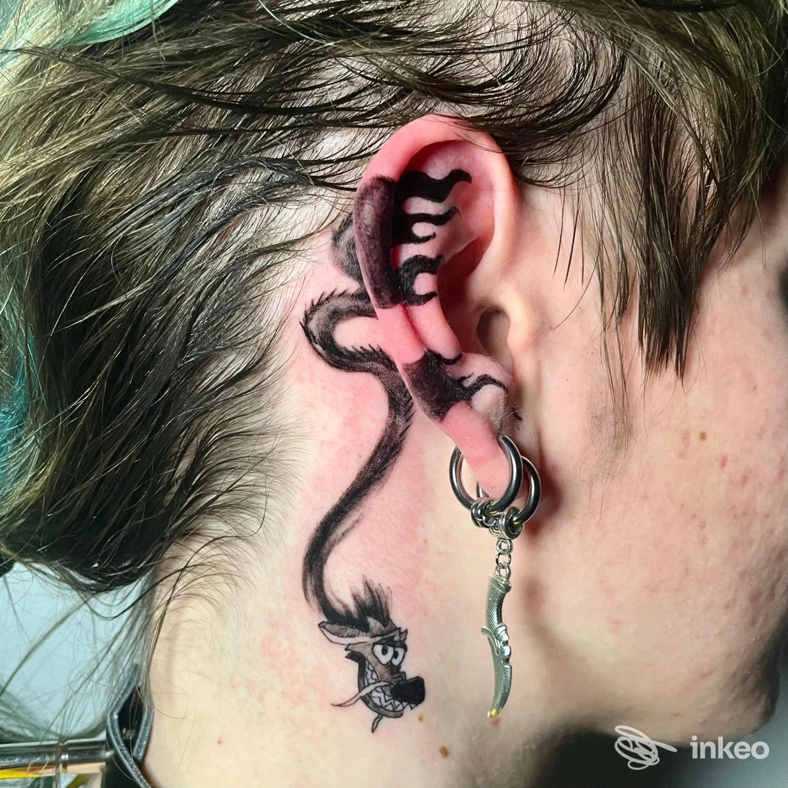 Tattoo nero dietro l'orecchio con figura stilizzata, foto per Nice Tattoo a Taranto.