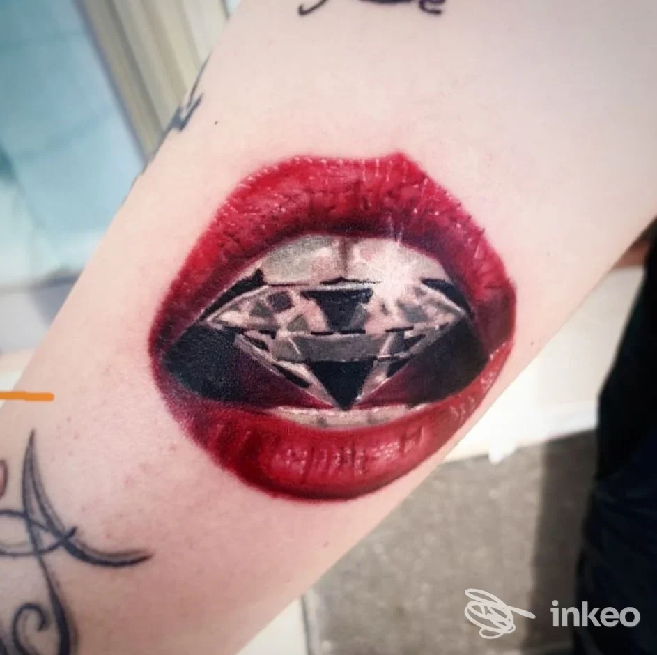 Tatuaggio realistico su avambraccio con labbra rosse e un diamante al centro, No rules tattoo, Marina di Ginosa.