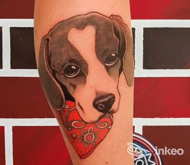 Tatuaggio di un cane che tiene un cuore rosso sull'avambraccio, Personalink Tattoo, Cisternino.
