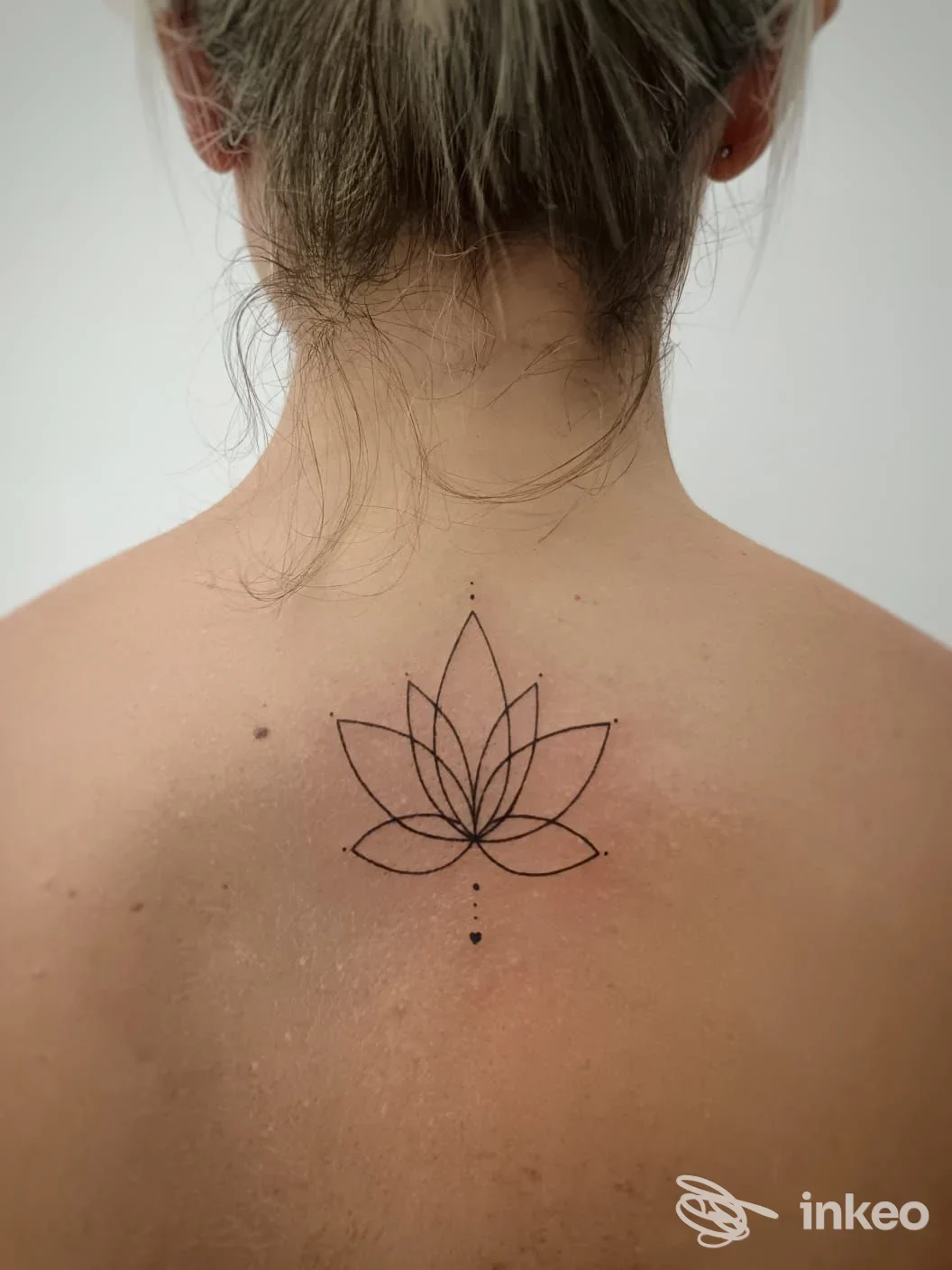Tatuaggio lotus lineare sulla parte superiore della schiena, immagine fornita da Aeternus Tattoo Studio, Crispiano.