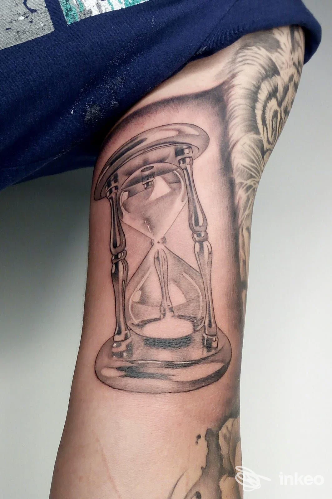 Tatuaggio realistico a clessidra sull'interno del braccio, lavoro di Aeternus Tattoo Studio a Crispiano.
