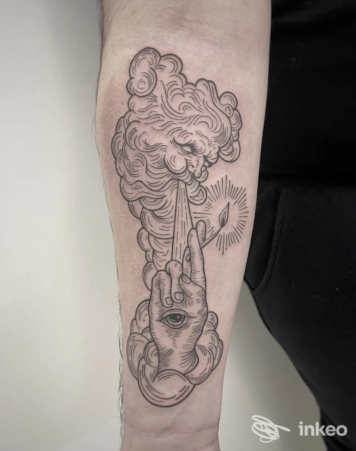 Tatuaggio sull'avambraccio raffigurante una mano stilizzata con occhio, nuvole e raggio, eseguito da Aeternus Tattoo Studio a Crispiano.