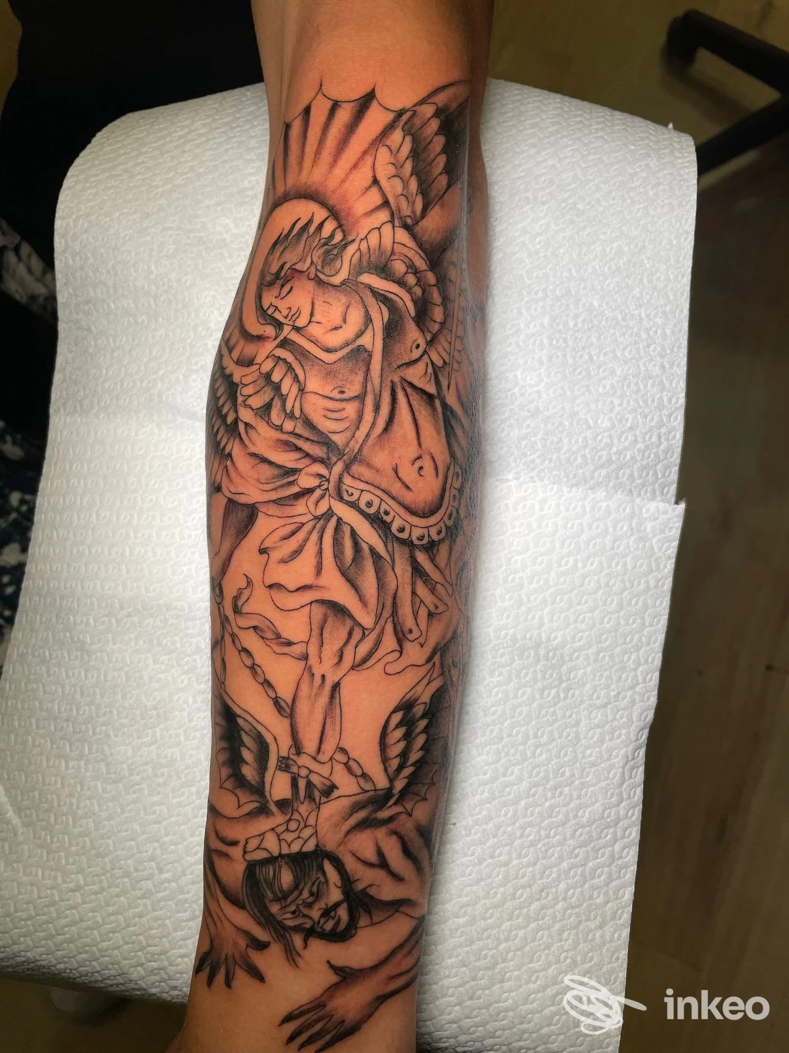 Tatuaggio black & grey su avambraccio raffigurante figure angeliche e volti stilizzati, Anima Tattoo Club, Foggia.